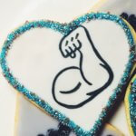 Decorated cookie of arm making a big muscle on a heart shape