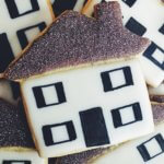 Decorated cookie of a house with gray roof and black front door and shutters
