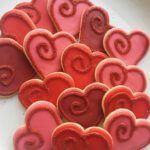 Plate of red heart shaped cookies with spiral sugar design for home baking business