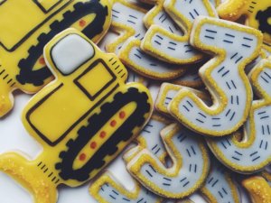 Cookies decorated as bulldozers and the number 3 cookies with road markings