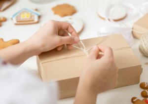 Woman tying string on a brown gift box that inspired a home cookie business