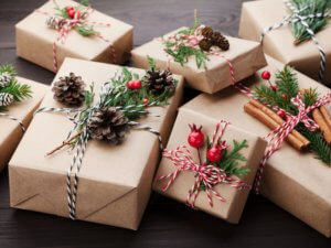 Pile of holiday presents wrapped in brown paper with pine cones and evergreen twigs