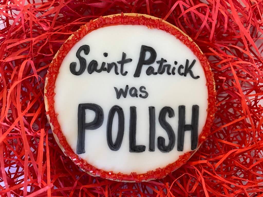 White cookie with red sparkly sugar that reads Saint Patrick was Polish
